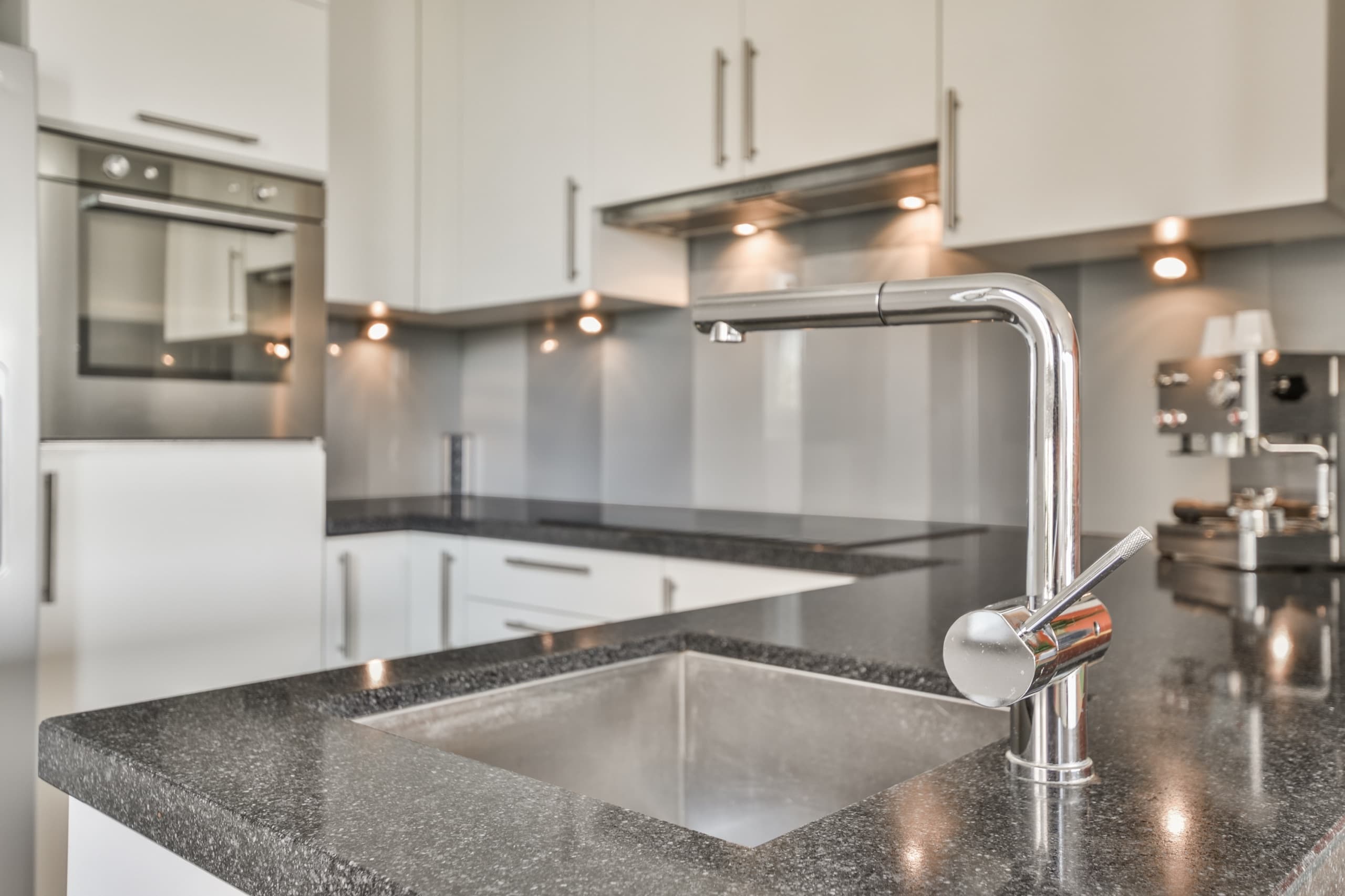 Spotless kitchen with granite counters and clean white cabinets