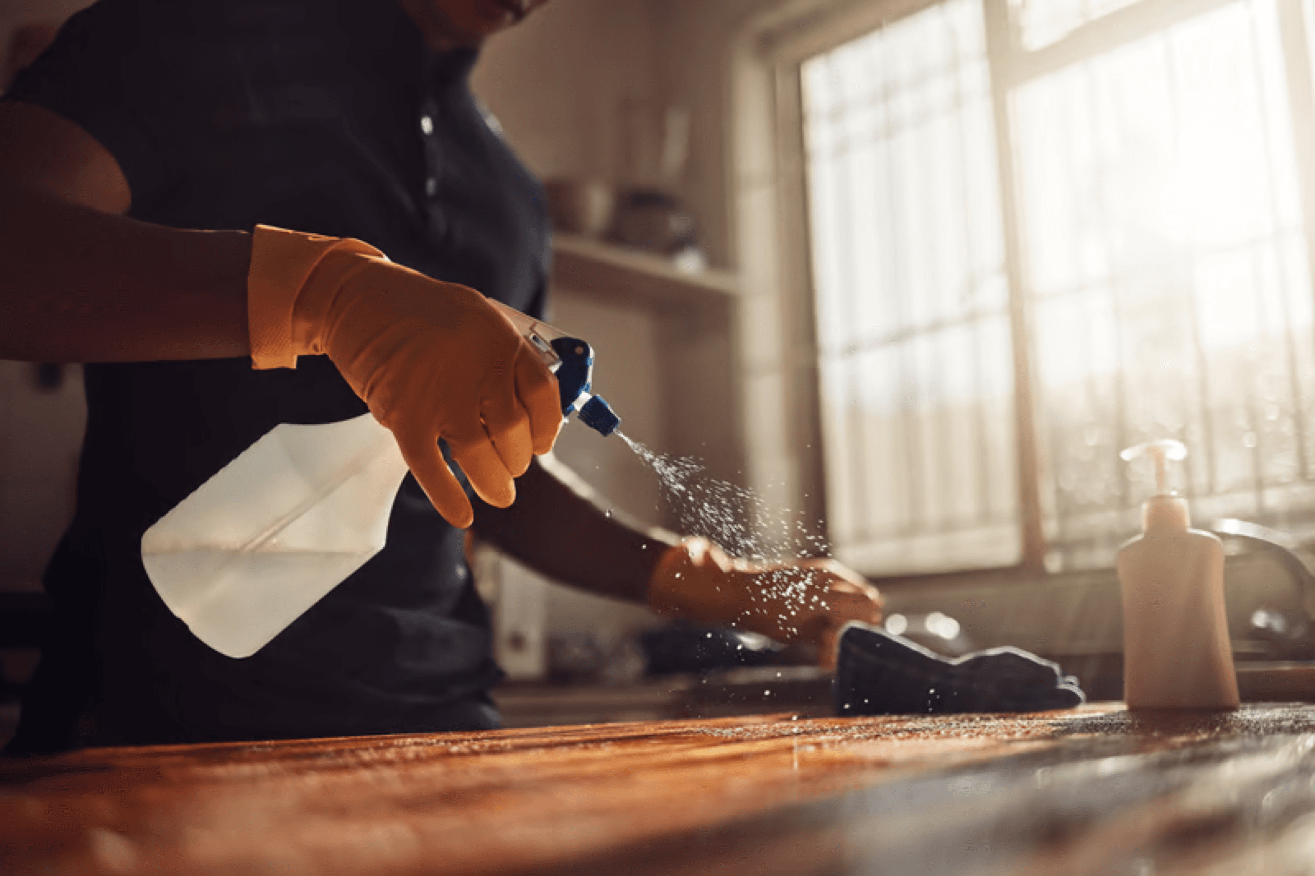 Close up of hands wiping a counter surface clean